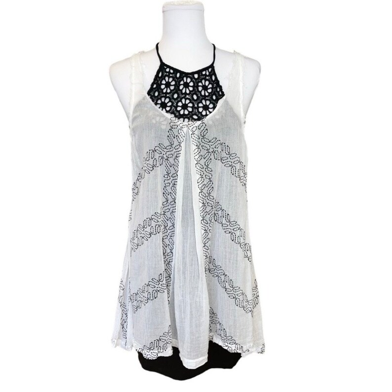 May include: White sleeveless top with a black crochet neckline and a peace sign pattern.