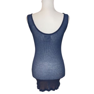 May include: A navy blue sleeveless knit tank top with a ribbed texture and a scalloped hem.