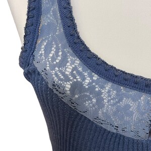 May include: A blue ribbed tank top with a lace trim around the neckline.