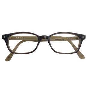 May include: Dark brown eyeglasses with a rectangular frame and light brown arms. The Paul Smith logo is visible on the left arm. The glasses have a classic, understated design.