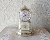 Golden table clock under vintage bell