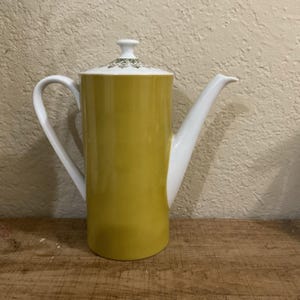 May include: A set of three ceramic mugs with a speckled, matte finish in cream, light grey, and dark grey. Each mug has a simple, minimalist design and a rounded handle.
