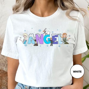 a woman wearing a white t - shirt with the word angel on it