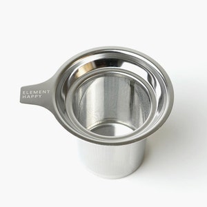 May include: A stainless steel tea infuser with a handle that says "ELEMENT HAPPY".