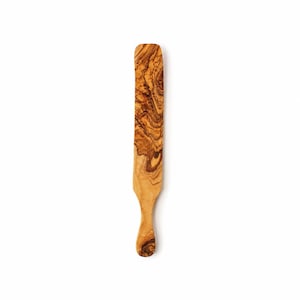 May include: A long, flat wooden spreader with a rounded top and a contoured handle. The utensil features a distinct, swirling grain pattern in shades of light tan, golden yellow, and deep brown, showcasing the natural texture of the wood grain.