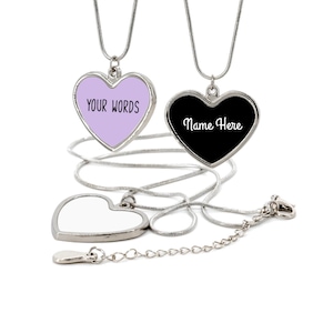 May include: Two silver heart-shaped necklaces with chains. One heart is lavender with the text "YOUR WORDS" and the other is black with the text "Name Here".