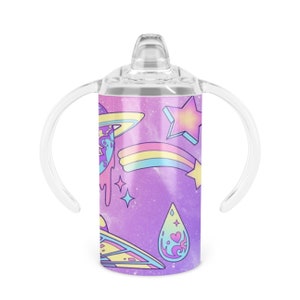May include: A purple stainless steel tumbler with a clear lid and two clear handles. The tumbler features a space-themed design with planets, stars, a rainbow, and a UFO.