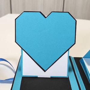 Álbum de recortes hecho a mano con corazón emergente y espacios para fotografías