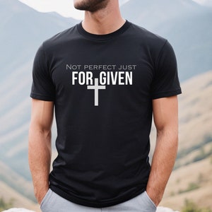 Peut inclure: T-shirt noir avec un texte blanc qui dit "Not perfect just FORGIVEN" avec une croix blanche sous le texte.