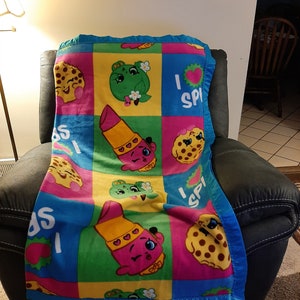 Shopkins&#39; Strawberry Kiss, Kooky Cookie, Lippy Lip and Apple Blossom, Kids Fleece Blanket with bright blue satin trim