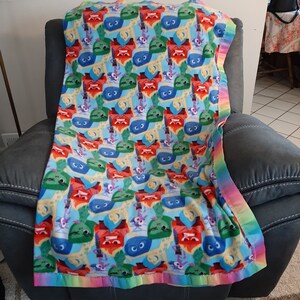 Inside Out&#39;s characters Disgust, Joy, Sadness, Fear and Anger, Kids Fleece Blanket with a multi colored satin trim.