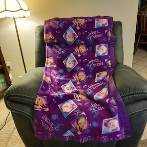 Frozen Elsa and Anna &quot;Sisters Forever&quot; Kids Fleece Blanket with dark purple satin trim.