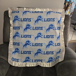 Detroit Lions, Infant Receiving Fleece Blanket with a matching gray or royal blue satin trim
