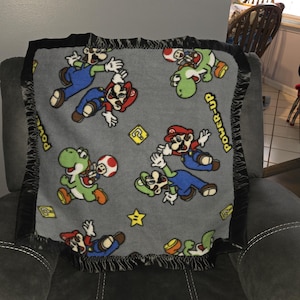Mario, Luigi, Toad, Infant Receiving Crib Fleece Blanket with a matching black satin trim