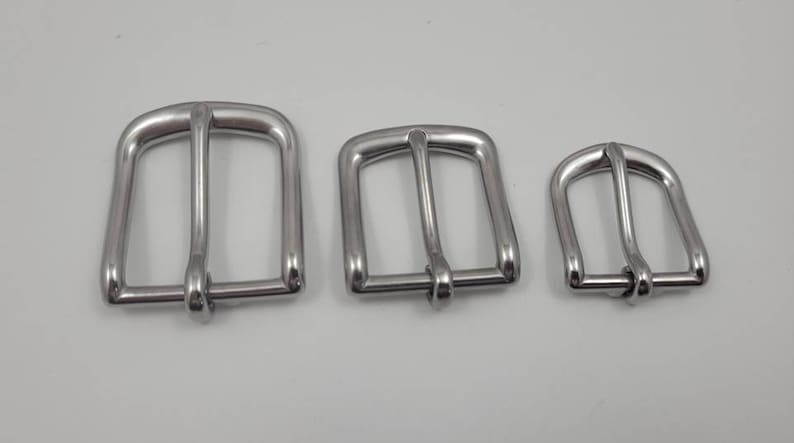 Puede incluir: Tres hebillas de cintur&oacute;n de metal plateado de diferentes tama&ntilde;os. Las hebillas son todas de forma rectangular con un acabado liso y pulido.