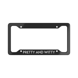May include: Black license plate frame with the words "PRETTY AND WITTY" in white. The frame has a glossy finish and is rectangular with rounded corners and mounting holes.