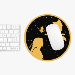 May include: A round black mouse pad with a gold silhouette of a woman and a dragon on a starry background.