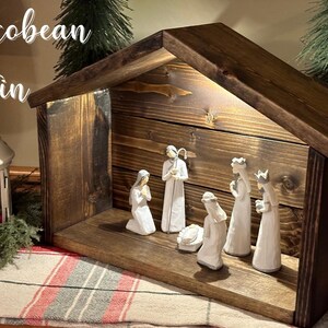 Peut inclure: Une cr&egrave;che en bois avec une teinture brun fonc&eacute;. La sc&egrave;ne comprend des figurines de Marie, Joseph, l'enfant J&eacute;sus et les trois rois mages. Le texte "Jacobean Stain" est visible en haut &agrave; gauche.