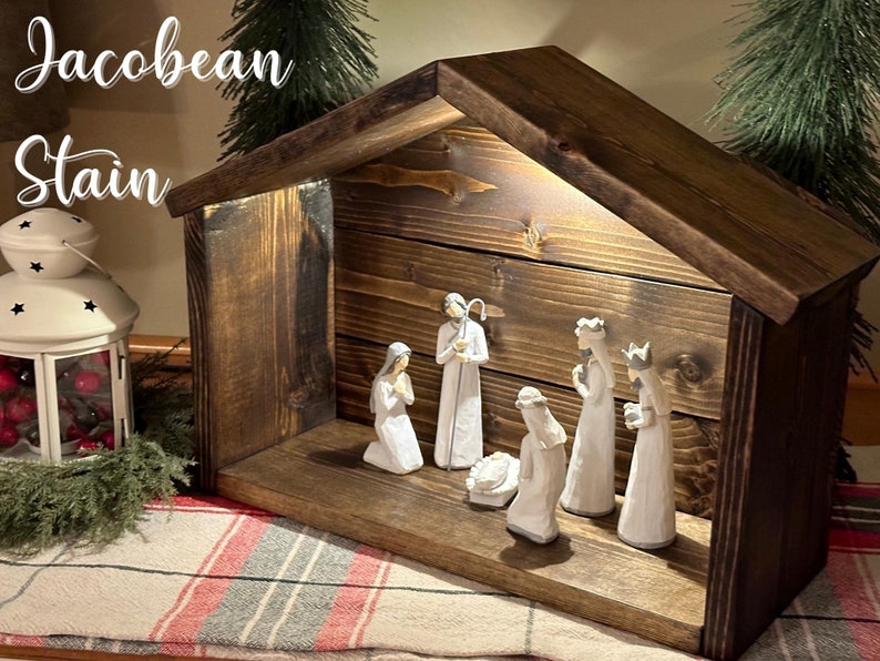 Peut inclure: Une cr&egrave;che en bois avec une teinture brun fonc&eacute;. La sc&egrave;ne comprend des figurines de Marie, Joseph, l'enfant J&eacute;sus et les trois rois mages. Le texte "Jacobean Stain" est visible en haut &agrave; gauche.
