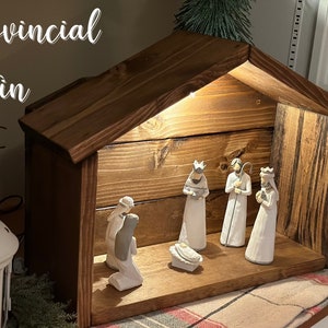 Peut inclure: Une cr&egrave;che en bois avec une teinture provinciale. La sc&egrave;ne comprend des figurines de la sainte famille et des trois rois mages. Le texte "Provincial Stain" est visible en haut &agrave; gauche.
