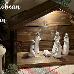 Peut inclure: Une cr&egrave;che en bois avec une teinture fonc&eacute;e. La sc&egrave;ne comprend des figurines de Marie, Joseph, des trois rois mages et de l'enfant J&eacute;sus dans une mangeoire. Le texte "Jacobean Stain" est visible en haut &agrave; gauche.