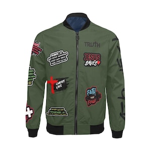 May include: Olive green bomber jacket with black trim and multiple patches. Patches include text like "JESUS SAVES", "CHRIST LIKE", and Bible verses. The jacket has a reversible design with a navy blue interior.