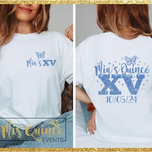 Peut inclure: T-shirt blanc avec texte bleu pailleté et motif papillon. Le devant du t-shirt indique "Mia's XV". Le dos du t-shirt indique "Mia's Quince XV" avec la date 10/05/24.