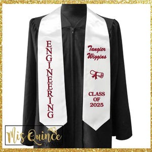Könnte beinhalten: Eine schwarze Abschlussrobe mit einem weißen Schärpe. Auf der Schärpe steht das Wort "ENGINEERING" in kastanienbraunen Buchstaben. Auf der anderen Seite der Schärpe stehen ein Name, eine Diplomgrafik und "CLASS OF 2025" in kastanienbraunen Buchstaben.