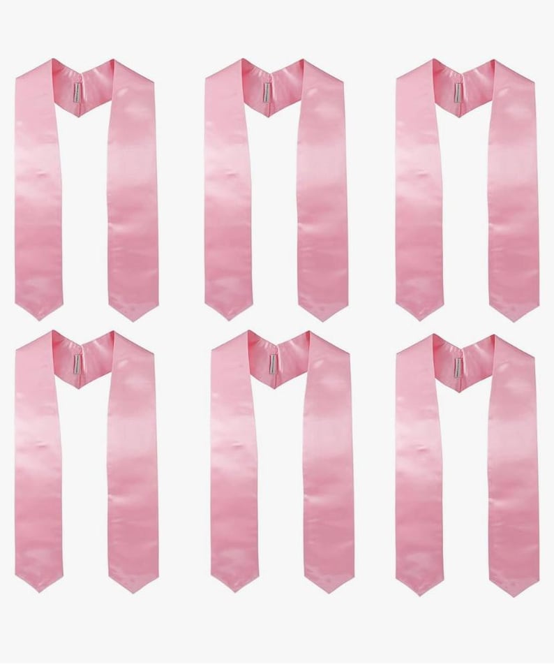 May include: Six light pink graduation stoles. Each stole is made of a smooth, satin-like material and features a V-neck design. The stoles are arranged in a grid pattern, showcasing their identical design and colour.