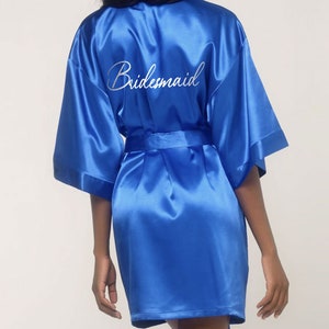 May include: A royal blue satin robe with the word 'Bridemaid' embroidered on the back in white.