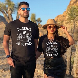 May include: A couple wearing matching black t-shirts with white text and graphics. The shirts say "Til Death Do Us Part" with a skeleton hand design and the date "07/18/24".