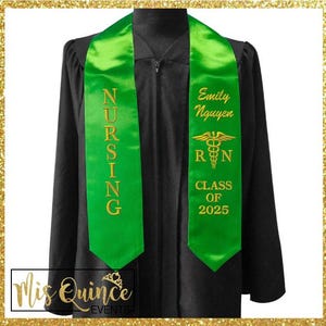 May include: A black graduation gown with a bright green sash. The sash is embroidered with "NURSING" in gold lettering on one side and the name "Emily Nguyen", a medical symbol, "R N", and "CLASS OF 2025" on the other.