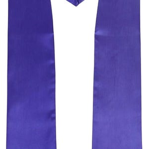 May include: A plain purple graduation sash made from a smooth, satin-like fabric. The sash is designed to be worn over the shoulders, with a V-neck shape at the front and two long panels. The color is a rich, royal purple, suitable for a graduation ceremony.