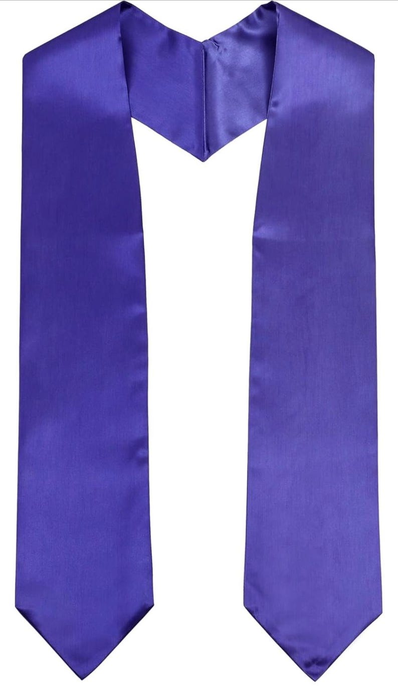 May include: A plain purple graduation sash made from a smooth, satin-like fabric. The sash is designed to be worn over the shoulders, with a V-neck shape at the front and two long panels. The color is a rich, royal purple, suitable for a graduation ceremony.