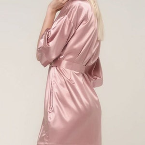 May include: A pink satin robe with a tie belt.