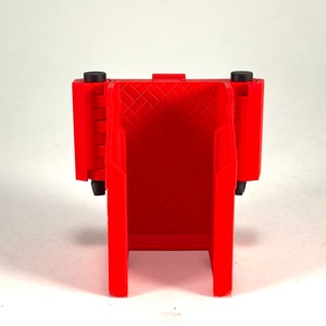 Puede incluir: Caja de almacenamiento de pl&aacute;stico roja con tapa con bisagras y un patr&oacute;n de diamante en la parte delantera. La caja tiene dos pies de pl&aacute;stico negro en la parte inferior.