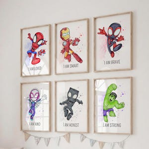 May include: A set of six framed wall art prints featuring watercolor-style illustrations of superheroes. Each print displays a character with a caption: I AM LOVED, I AM SMART, I AM BRAVE, I AM KIND, I AM HONEST, and I AM STRONG. The frames are light wood.
