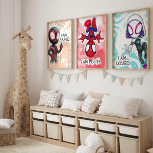 May include: Three framed superhero art prints with the phrases "I AM BRAVE", "I AM POLITE", and "I AM LOVED". The artwork features illustrations of Spider-Man characters in a child's bedroom setting. A large giraffe toy and storage unit are also visible.
