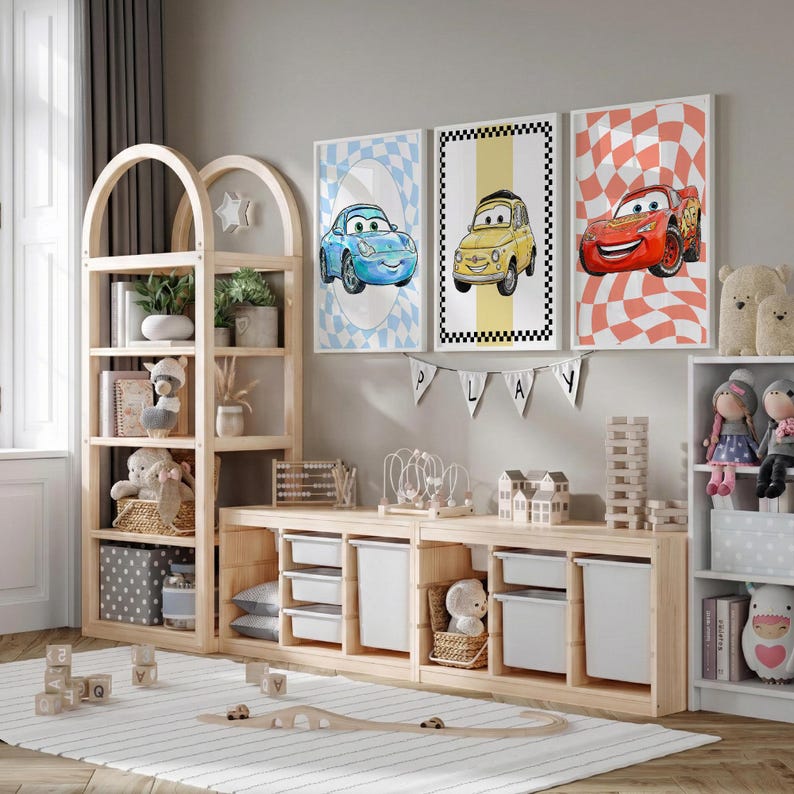 Pode incluir: Um quarto infantil com m&oacute;veis de madeira clara, incluindo uma estante e uma unidade de armazenamento. Tr&ecirc;s impress&otilde;es emolduradas com tema de carros penduradas na parede. O quarto &eacute; decorado com brinquedos, plantas e um tapete. Uma faixa diz "PLAY".