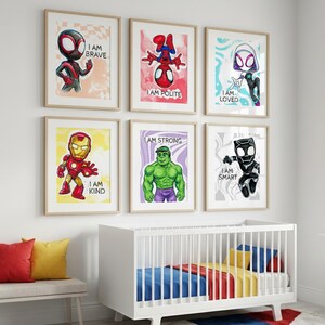 May include: Six framed superhero art prints with inspirational messages. The prints feature characters like Spider-Man, Iron Man, and Hulk, each accompanied by positive affirmations such as "I am Brave" and "I am Kind". The artwork is displayed above a white crib.