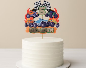 Könnte beinhalten: Ein weißer Kuchen mit einer Tortenaufleger-Dekoration mit Monstertrucks, Flammen, Schachflaggen und der Zahl 5. Der Name "BRAIDEN" ist ebenfalls auf dem Aufleger zu sehen. Der Kuchen steht auf einem weißen Teller.
