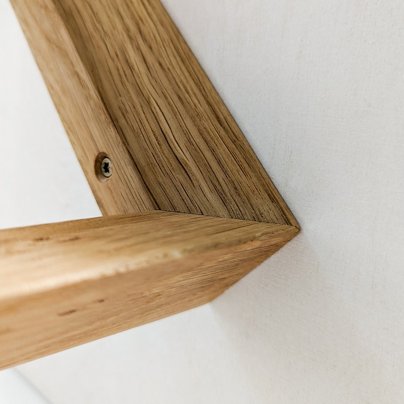 K&ouml;nnte beinhalten: Nahaufnahme eines Holzregalbrettes mit einer sichtbaren Schraube. Das Regalbrett ist aus hellbraunem Holz mit nat&uuml;rlicher Maserung.