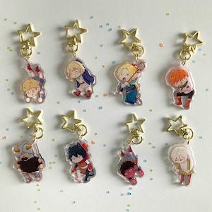 May include: Eight colorful keychains featuring cartoon characters with gold star-shaped charms. The characters are depicted in various poses and expressions.