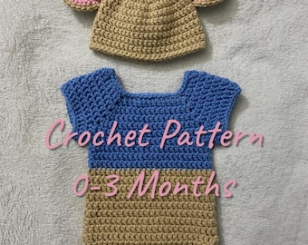 May include: A handmade crochet outfit for a baby, including a hat with pink-lined ears and a blue and tan romper. The text "Crochet Pattern 0-3 Months" is visible on the romper. The outfit is designed for newborns up to three months old.