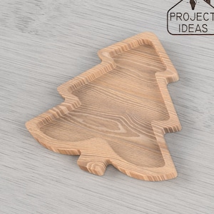 May include: A wooden Christmas tree-shaped serving tray. The tray is made of light brown wood with a natural grain pattern.