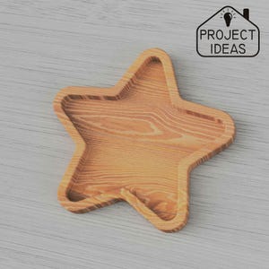 以下が含まれることがあります： 自然な木製の仕上げが施された、星型の木製トレイ。ジュエリー、鍵、その他の小物などを収納するのに最適です。