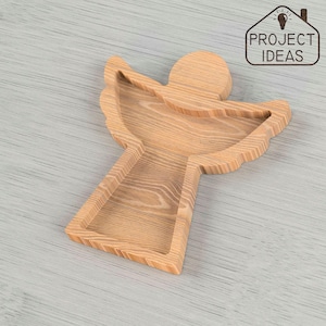 May include: A wooden angel-shaped serving tray with a natural wood finish. The tray has a shallow bowl in the center and wings on either side.