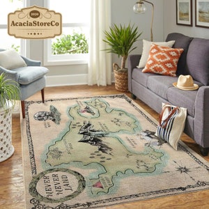 May include: A beige and green rug with a map of Neverland. The map features various locations, including Skull Rock, Mermaid Lagoon, and the Jolly Roger. The rug has a black border with the words "Never Never Land" in a decorative font.