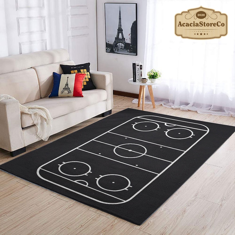K&ouml;nnte beinhalten: Schwarz-wei&szlig;er Hockeyfeld-Teppich. Der Teppich zeigt eine wei&szlig;e Umrandung eines Hockeyfeldes mit einem Mittelkreis und zwei Bully-Kreisen.