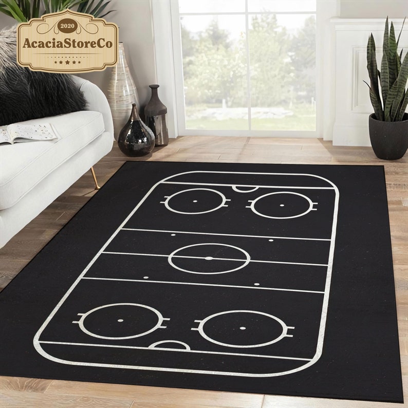 K&ouml;nnte beinhalten: Schwarz-wei&szlig;er Hockeyfeld-Teppich. Der Teppich zeigt eine wei&szlig;e Umrandung eines Hockeyfeldes mit Kreisen f&uuml;r die Bully-Punkte und die Torlinien.
